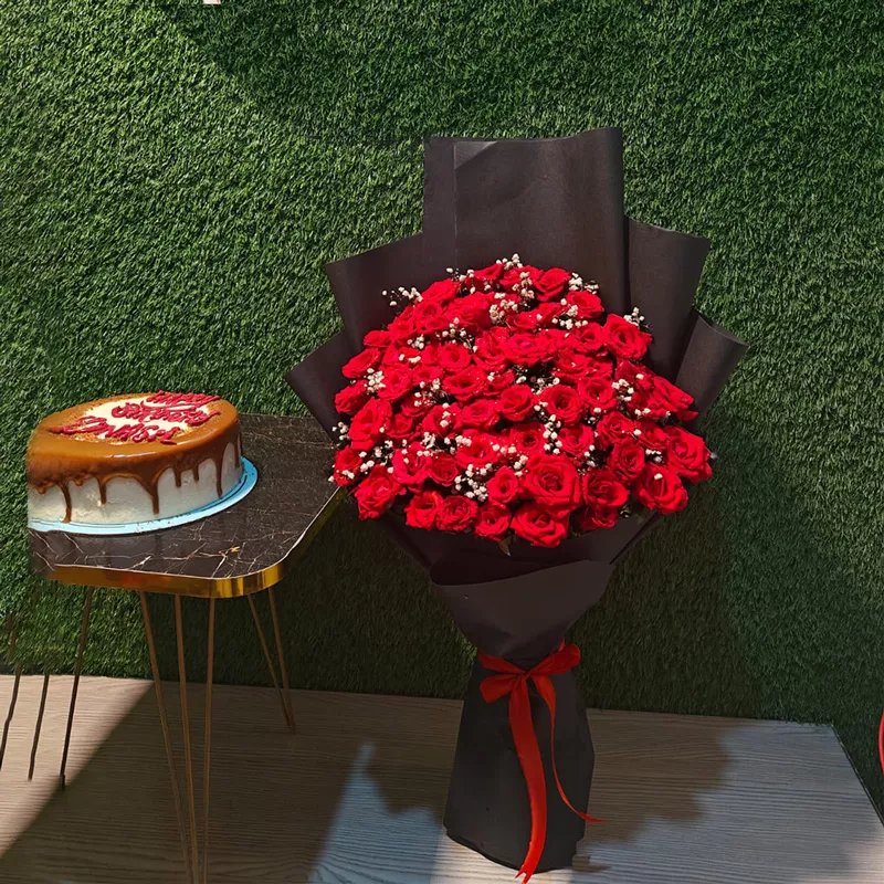 Grand 50 red roses bouquet in black wrap paired with a caramel drip birthday cake