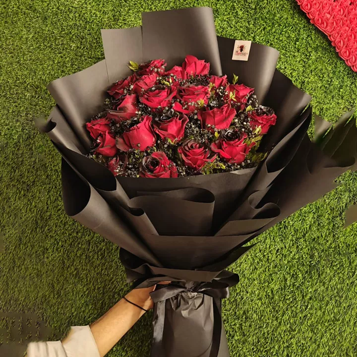 Premium bouquet of velvet deep red roses and black-dyed fillers in full black wrapping