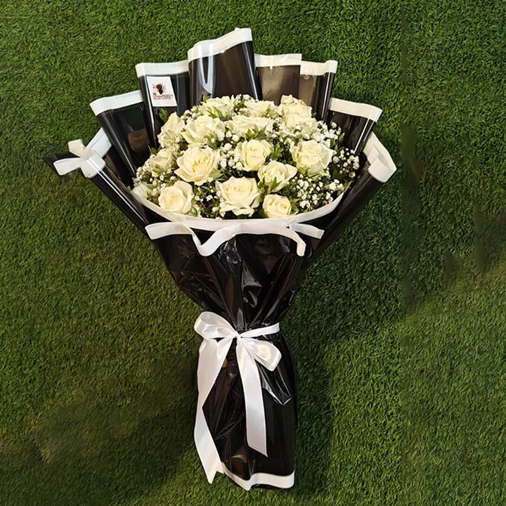 Dozen white roses bouquet with baby's breath, wrapped in black and white paper with white ribbon