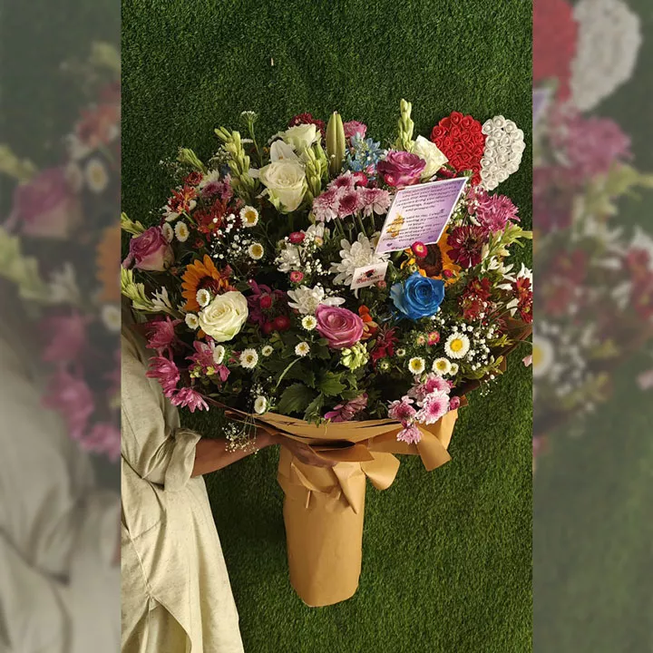 Oversized hand-tied mixed bouquet with roses, sunflowers, and blue-dyed roses in brown wrap