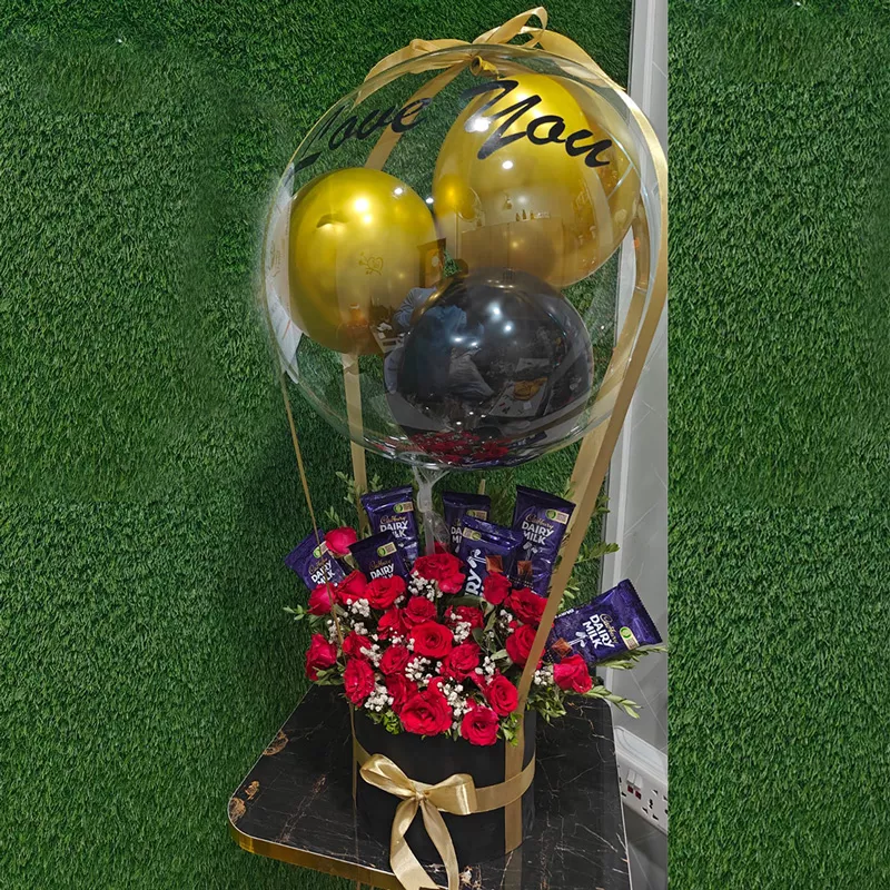 Hot air balloon flower box featuring red roses, chocolates, and "Love You" gold balloons