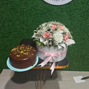 Elegant white flower box arrangement (roses/carnations) with a rich pistachio chocolate cake
