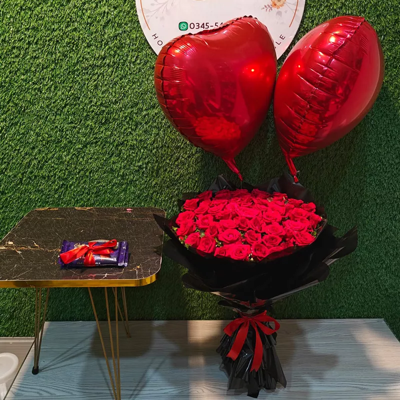 Fifty red roses bouquet in black wrap with two red foil heart balloons and chocolate bar