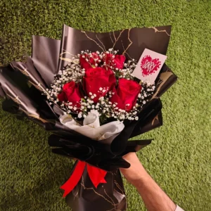 Red roses with white fillers in premium marble-patterned black wrapping and a 'Sorry' card