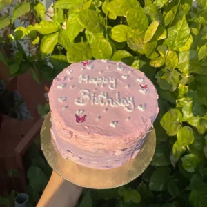 Pastel pink textured cake with edible pearls and fluttering paper butterflies