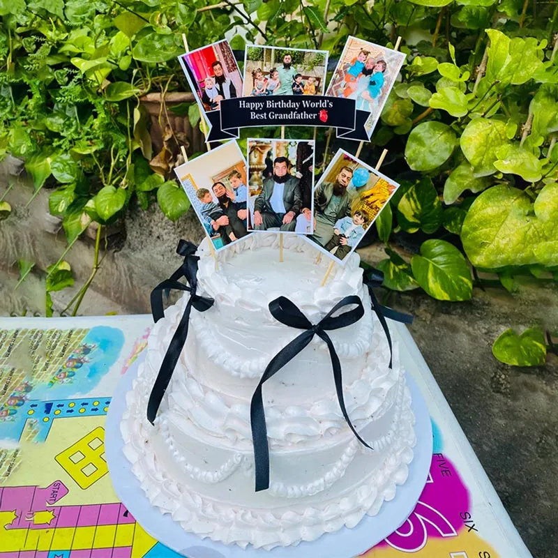 Multi-tier personalized photo cake with edible family pictures and black ribbons