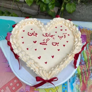 Heart cake with Urdu calligraphy Aap Hamari Jaan Ban Gaye and red bows