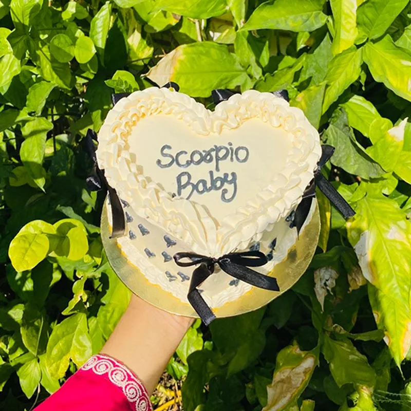 Black vintage heart cake with coquette aesthetic black ribbons and frilled piping